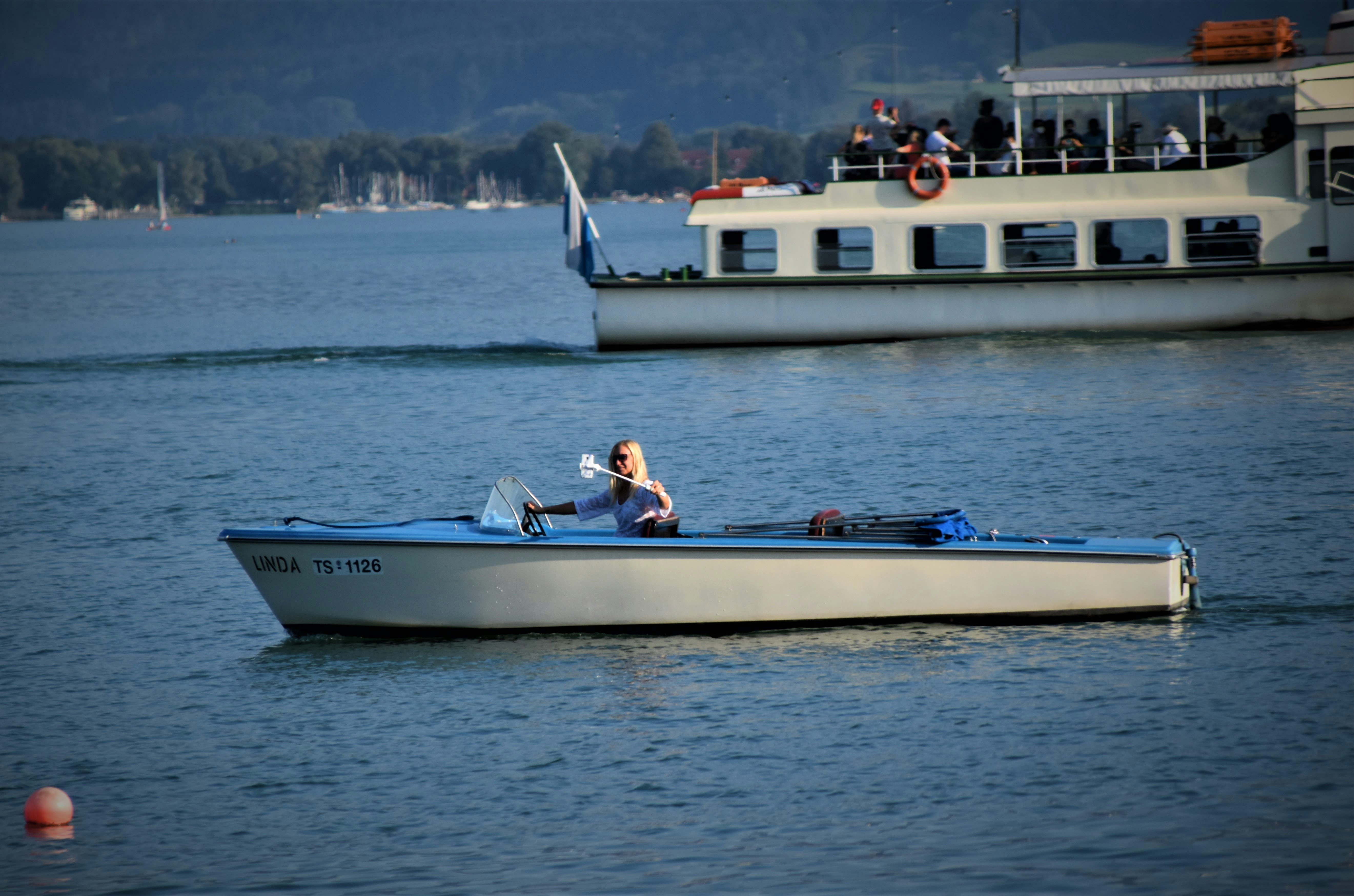 people riding on white and blue boat during daytime